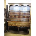 An Antique style oak dresser, with close boarded rack rack, the base fitted with three drawers