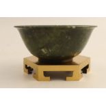 A Chinese simulated spinach jade bowl, of circular form on gilt metal stand