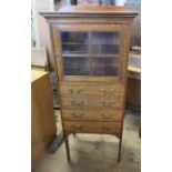 An Edwardian mahogany and satinwood cabinet, fitted with a glazed door over four long drawers, 20.