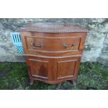 A 19th century serpentine fronted commode chest, with lift up top and gadrooned band, raised on