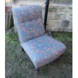 An Edwardian upholstered nursing chair with turned front legs