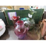 Two Victorian cranberry glass jugs, together with a Victorian green glass jug