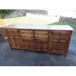 A large Ercol dresser base, width 85ins, depth 20ins, height 35ins