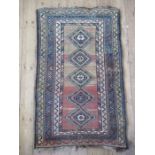 An Eastern design rug, with five lozenges to the field, 54ins x 32.5ins