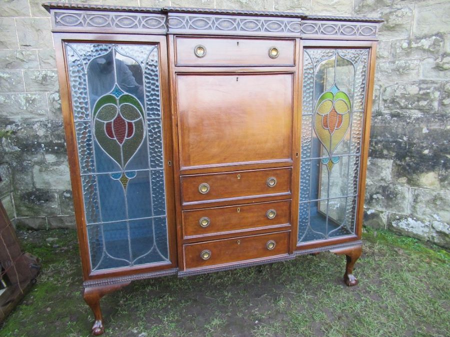 A mahogany cabinet, having central drawers flaked by glazed stained doors, width 57ins, height