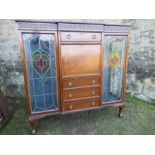 A mahogany cabinet, having central drawers flaked by glazed stained doors, width 57ins, height