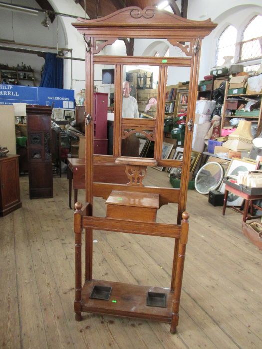 An Edwardian oak hall stand, with mirror, coat hooks, glove box and stick stand, height 77ins, width