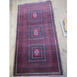 An Eastern design rug, with red ground, 84ins x 43ins, together with two other rugs