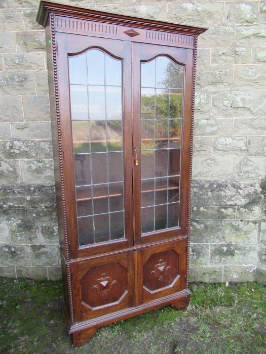 An oak glazed display cabinet,  width 37.5ins, height 76ins, depth 11ins
