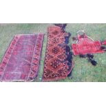 An Oriental design rug, in red and brown, 54ins x 38ins, together with two other decorative carpet