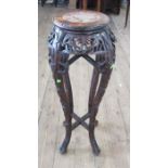 An Eastern hardwood jardiniere stand, the circular top inset with marble, having pierced and