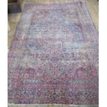 A highly patterned rug, decorated with flowers and scrolling leaves, 113ins x 77ins