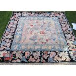 A 20th century rug, with black ground border and pastel coloured field, 84ins x 80ins