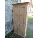 A pine double cupboard, having two pairs of fielded cupboard doors opening to reveal adjustable