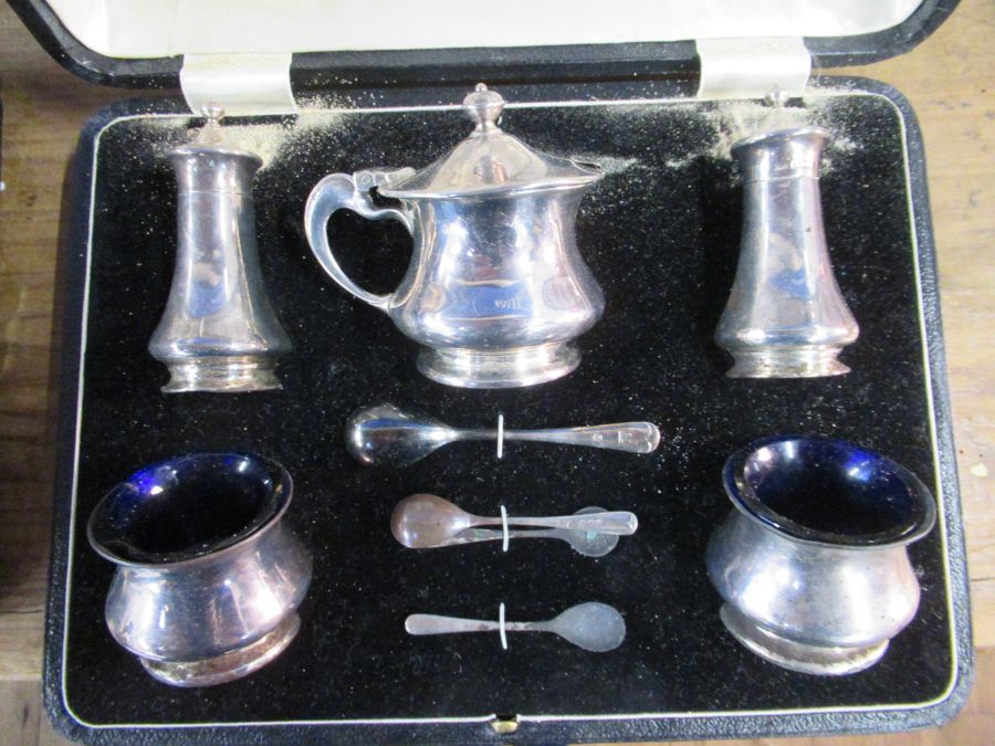 A cased hallmarked silver five piece condiment set, with spoons