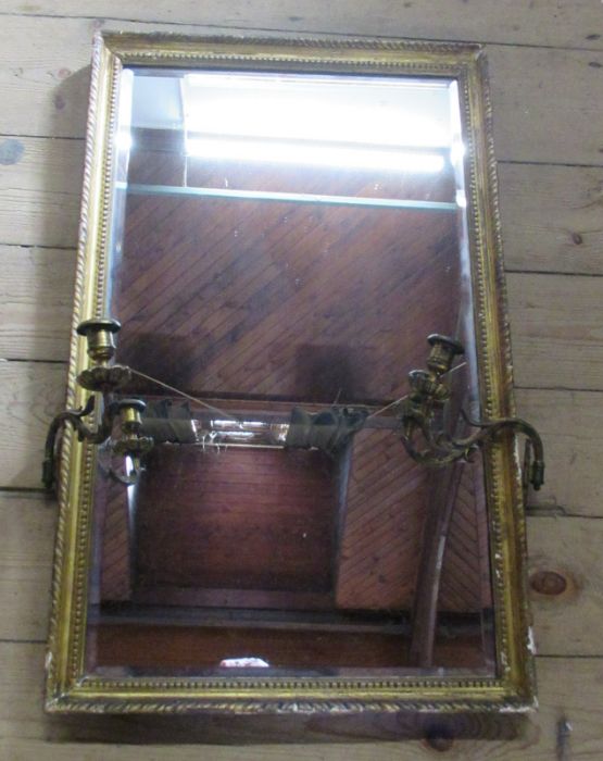 An Antique rectangular gilt framed wall mirror, with two gilt metal candleholders, 29ins x 18ins