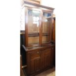 An Edwardian mahogany cabinet, the upper section having a pair of glazed doors with adjustable