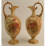 A pair of Royal Worcester quarter lobbed ewers, decorated with flowers to a blush ivory ground,