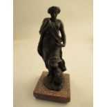 A metal study of a figure by a seated lion raised on a square tile  height 7"