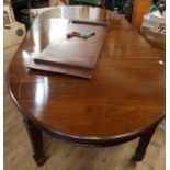An Edwardian mahogany wind out dining table, raised on carved legs, having three leaves, width
