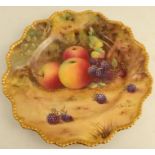 A Royal Worcester cabinet plate, decorated with fruit to a mossy background by T Lockyear, with