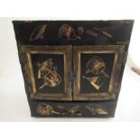 A late 19th century Japanese table cabinet fitted with draws and cupboard decorated with fans