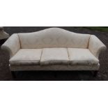 A yellow three seater settee, with shaped back, raised on mahogany legs, with fire labels, length