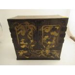 A Japanese table cabinet with gilt chinoiserie decoration, having 2 cupboard doors enclosing draws