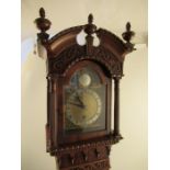 A small sized model of an 18th century long cased clock with arched finial pediment and having