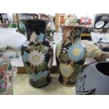 Two similar vases decorated with flowers to a black ground, heights 16ins and 15ins
