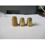 Three gold coloured thimbles, all unmarked