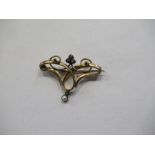 An Edwardian yellow metal brooch, formed as scrolls and set with stones