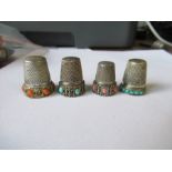 Four white metal thimbles, two set with coral roundels and two with turquoise