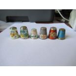 Five hallmarked silver and enamel thimbles, four decorated with flowers, one with a landscape, one