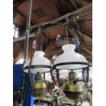 A near pair of metal hanging lights, with brass bowls and white glass shades, height approx 27ins