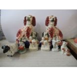 A pair of Staffordshire seated spaniels, in brown and white with pup spaniels at their feet,