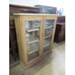 A pine cabinet, fitted with a pair of glazed doors and shelves, 45ins x 13ins, height 50.5ins