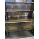 A 29th century oak dresser, with shelves to the back, the base fitted with drawers and cupboards, on
