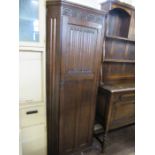 A hall cupboard with carved decoration to the door