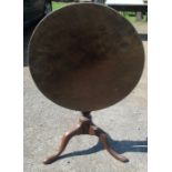 A 19th century mahogany tilt top table, the circular top raised on a turned column and three