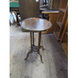 A mahogany topped circular occasional table, raised on four oak barley twist supports to outswept