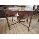 An Edwardian mahogany and inlaid bijouterie table, with beveled plates to glass, with shaped lid,