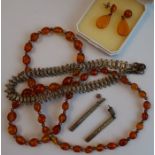 An amber bead necklace, with white metal spacers, together with a pair of amber drop earrings, a