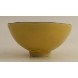 Dame Lucie Rie, a footed bowl, decorated with a bright yellow glaze and a blue line to the rim,
