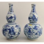 A pair of Chinese Kangxi gourd vases, decorated with figures on horse back hunting, with deer and