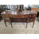 A late Georgian mahogany sideboard, having tambour sliding doors, flanked by cellarette drawer and