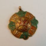 A Welsh Schools Football Association 9ct Gold and Enamel medal decorated with a dragon, the