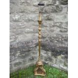 A 20th century giltwood standard lamp, with scrolling stand and ornate sections, the base with C