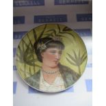 A hand decorated porcelain wall plaque of a girl in the Arts and Crafts style, signed Ellen Mallam