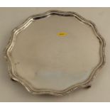 A silver salver, with shaped edge, raised on four feet, Sheffield 1933, weight 21oz
